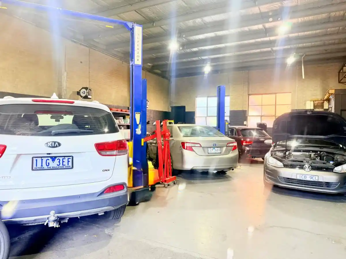 Kia Sorento, Toyota Camry, Audi A4 and Volkswagen Golf being worked on across the workshop floor