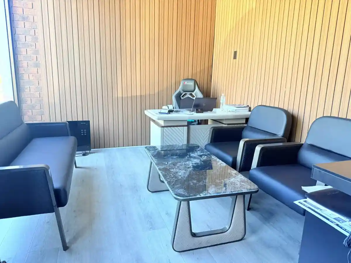 Customer waiting lounge with timber slat walls, leather seating and a stone coffee table
